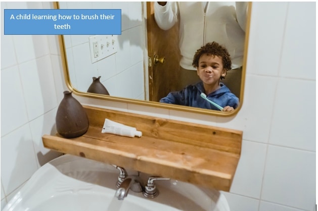 Uma criança aprendendo a escovar os dentes